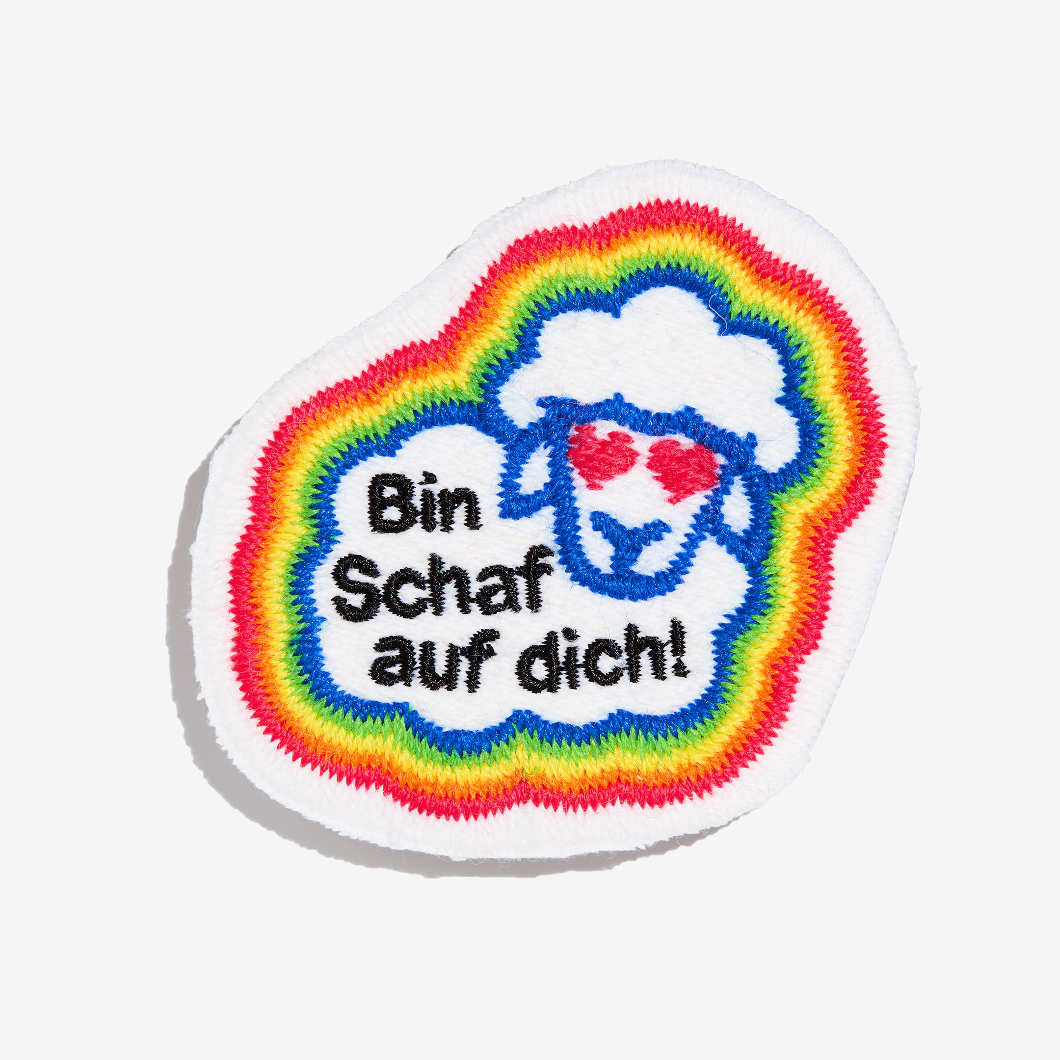 Patch "Bin Schaf auf dich!" made of gay sheep wool on a white background.