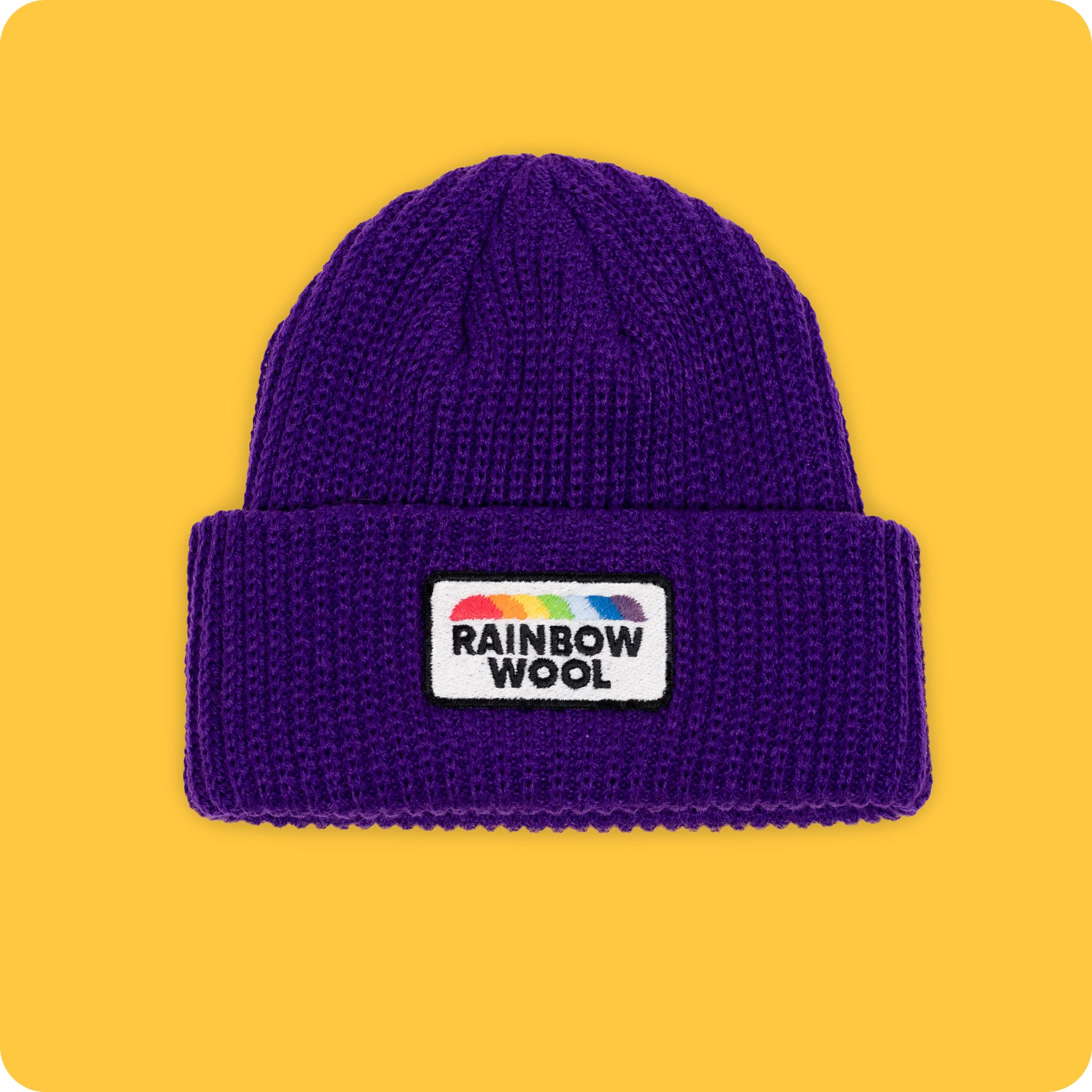 Vorderseite der Mütze "Rainbow Wool" aus der limitierten Kollektion auf einem gelben Hintergrund