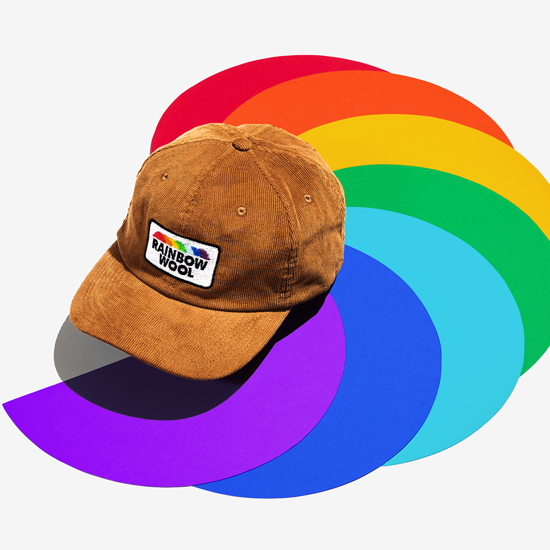 "Rainbow Wool" Corduroy Cap with a logo motif made of gay sheep wool on a colorful background.