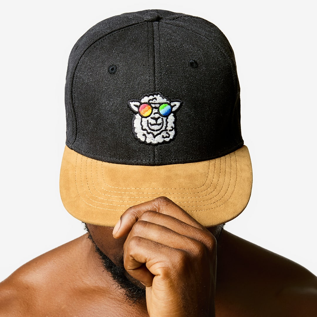 "Sunny" Skater Cap with a sheep motif made of gay sheep wool on a male model’s head.