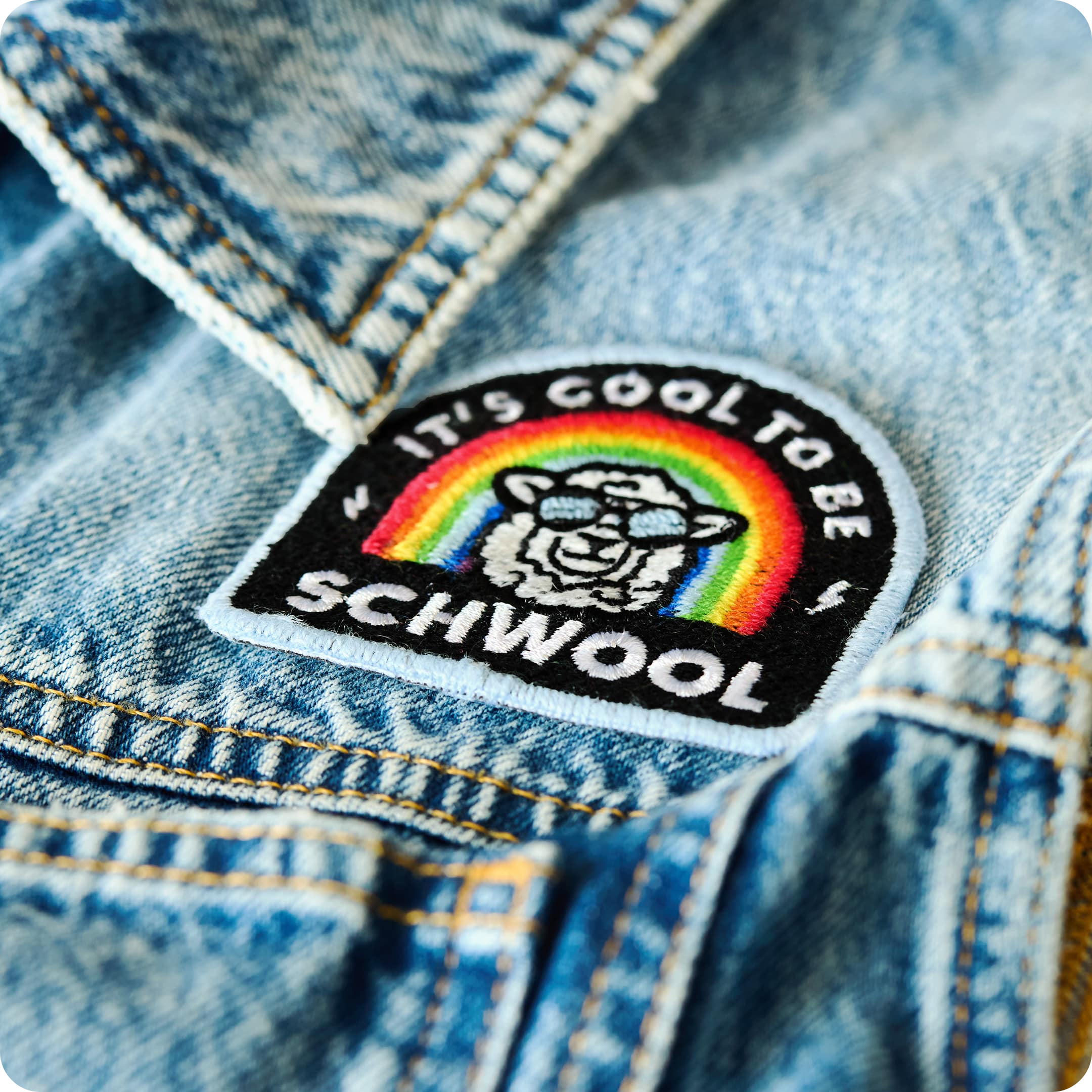 Patch "It's cool to be schwool" aus schwuler Schafwolle auf Jeansstoff.