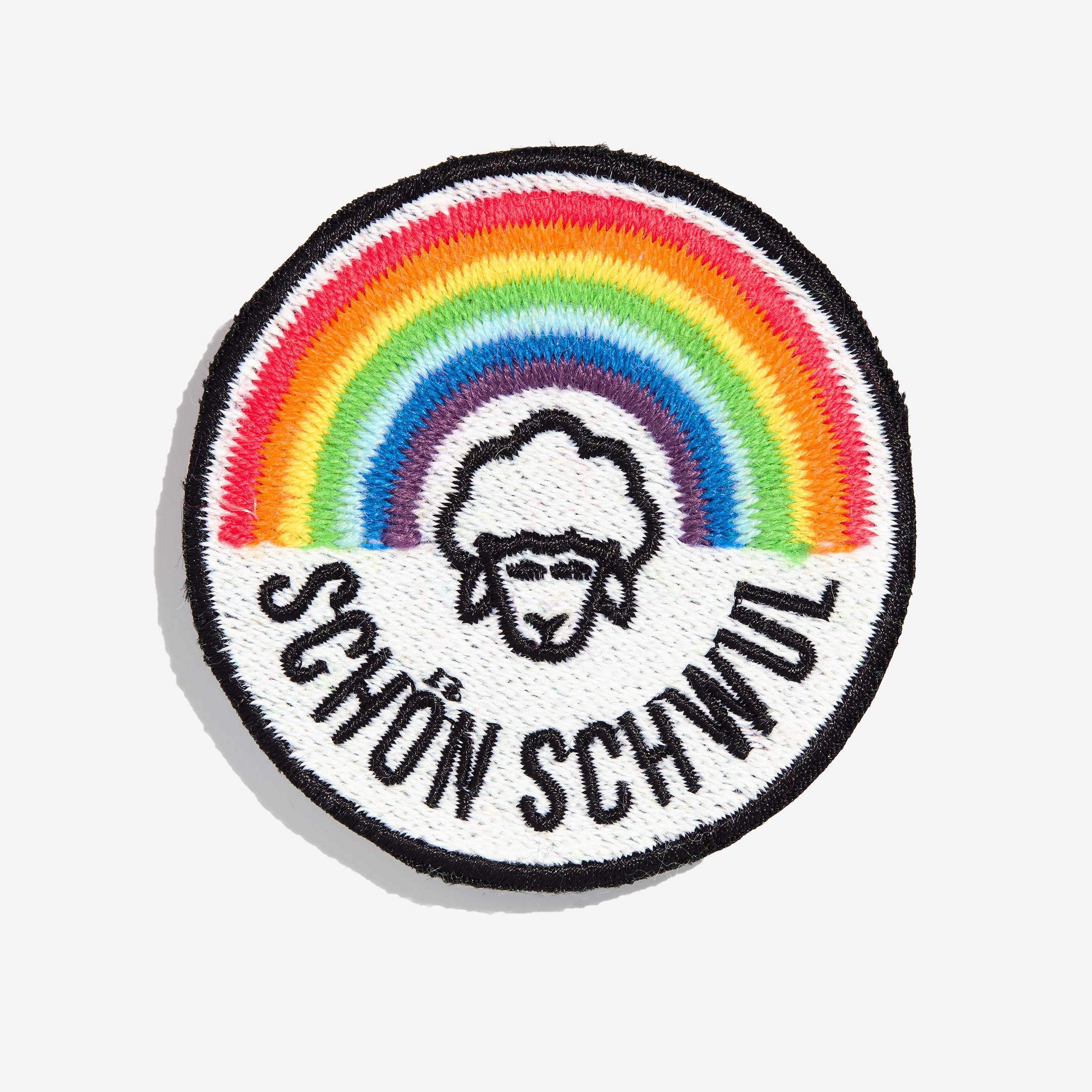 Patch "schön schwul" made of gay sheep wool on a white background.