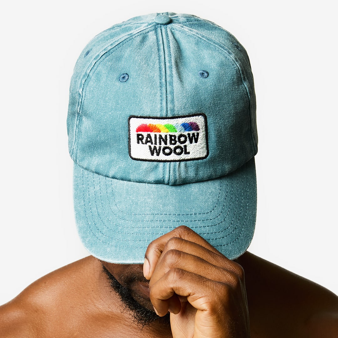 "Rainbow Wool" Vintage  Cap with a logo motif made of gay sheep wool on a male model’s head.