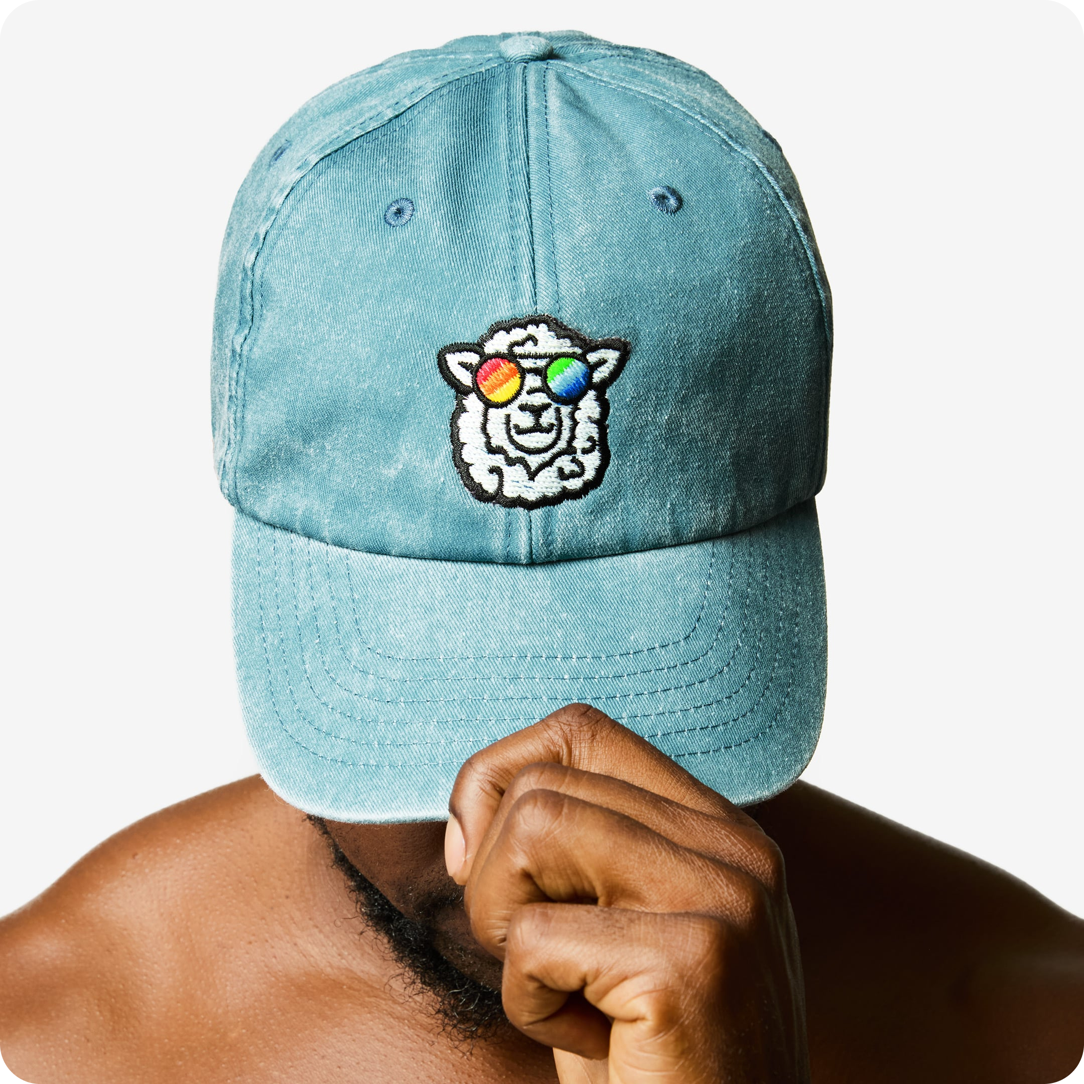 "Sunny" Vintage Cap by Rainbow Wool "Sunny" Vintage Cap with a sheep  motif made of gay sheep wool on a male model’s head.