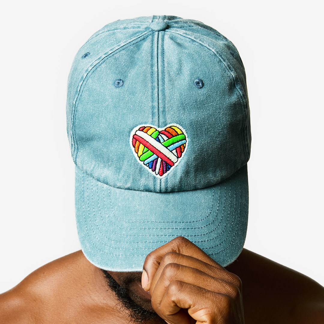 "Woolen Heart" Vintage-Cap mit einem Herz-Motiv aus schwuler Schafwolle auf dem Kopf eines männlichen Models.