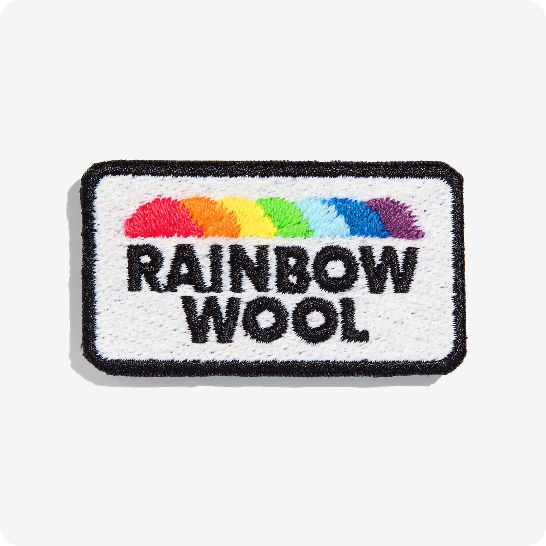 Patch "Rainbow Wool" aus schwuler Schafwolle auf einem weißen Hintergrund.