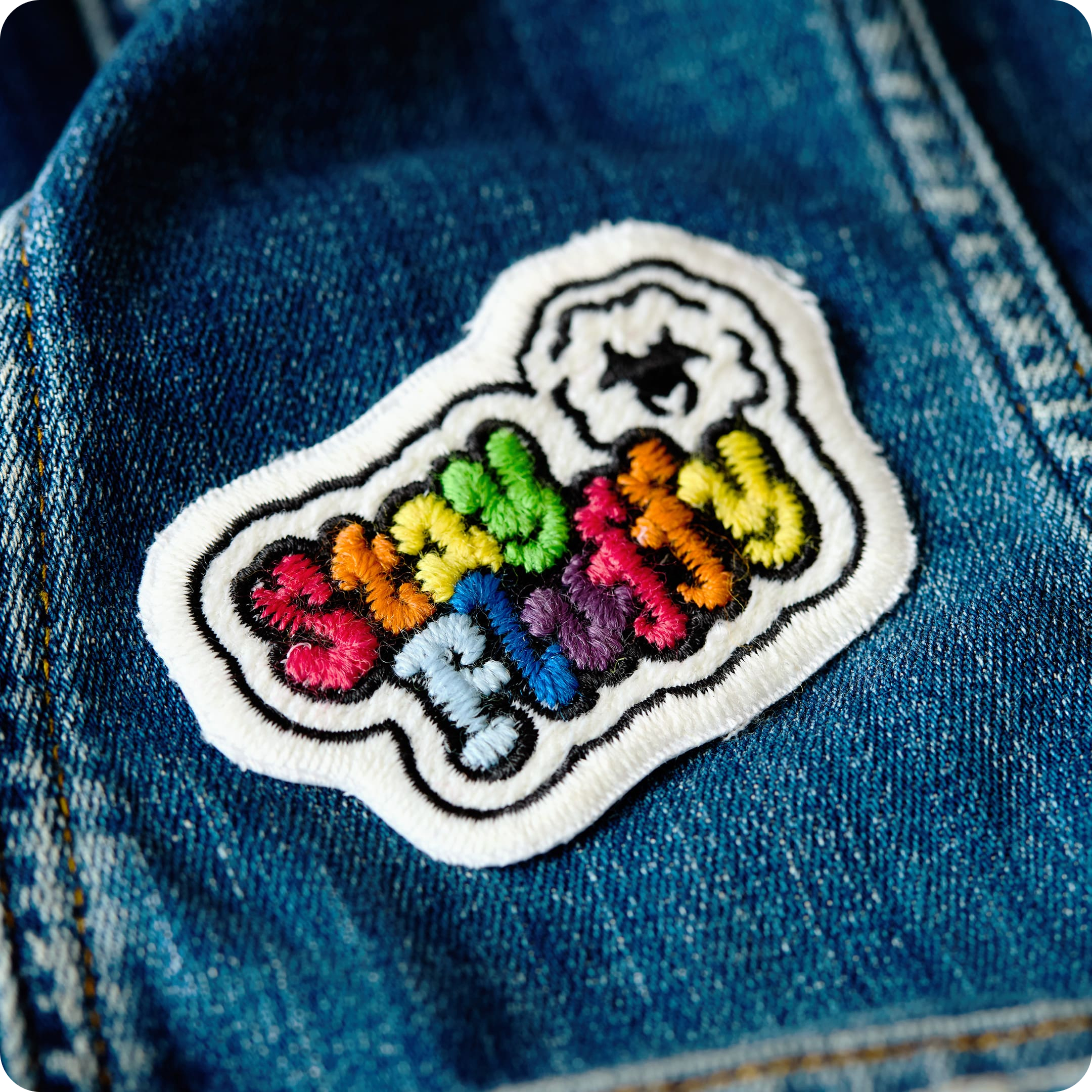 Patch "stay fluffy" made of gay sheep wool on denim.