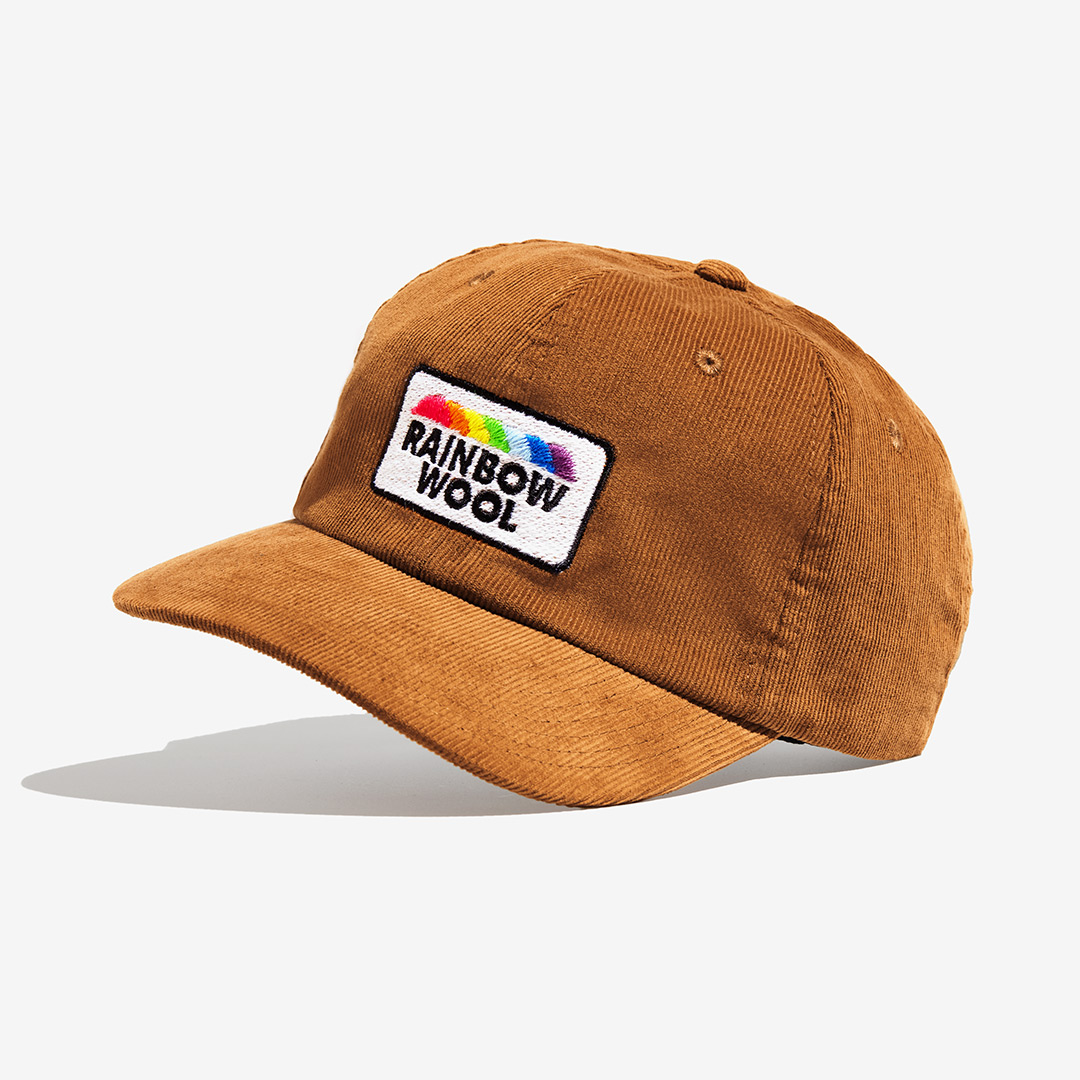 "Rainbow Wool" Cord-Cap mit einem Logo-Motiv aus schwuler Schafwolle auf einem weißen Hintergrund.