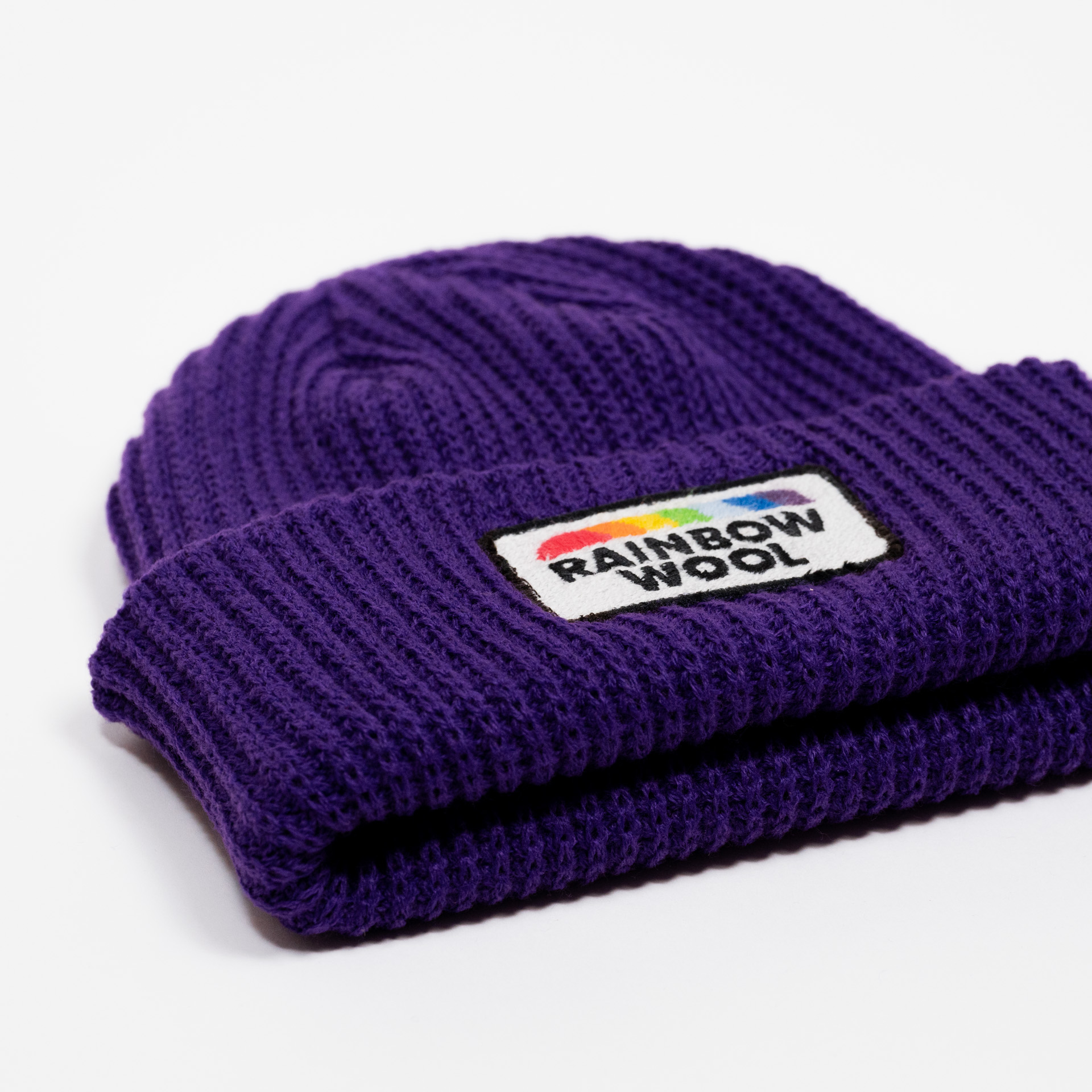 Close up of the limited edition beanie "Rainbow Wool" on a white background 