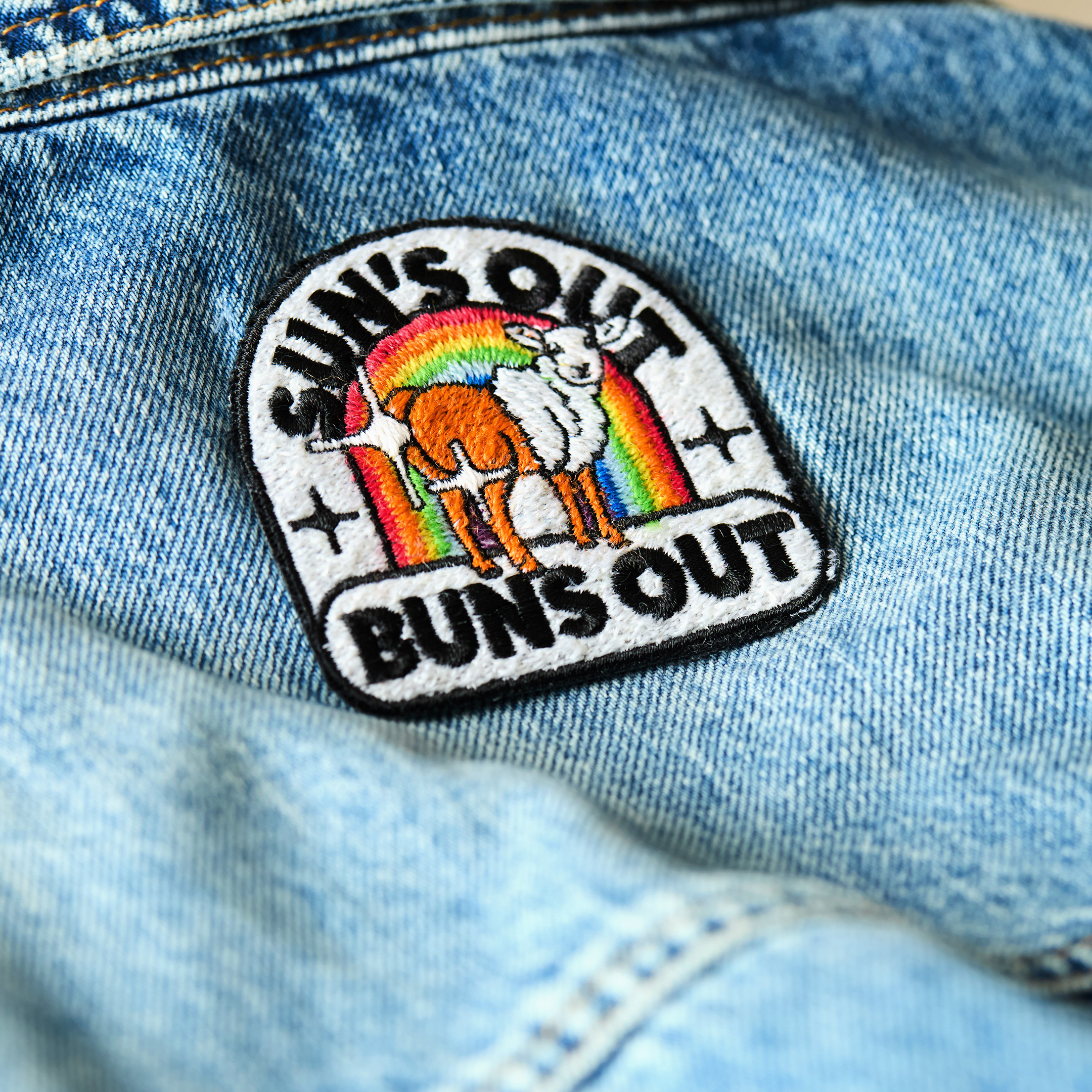 Patch "sun's out buns out" aus schwuler Schafwolle auf Jeansstoff.