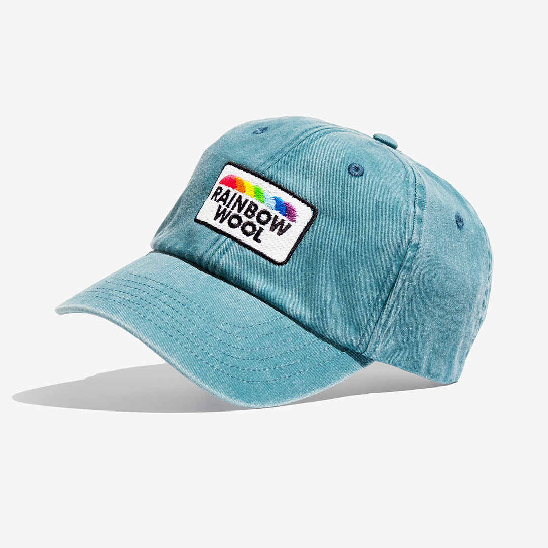 "Rainbow Wool" Vintage Cap with a logo motif made of gay sheep wool on a white background.