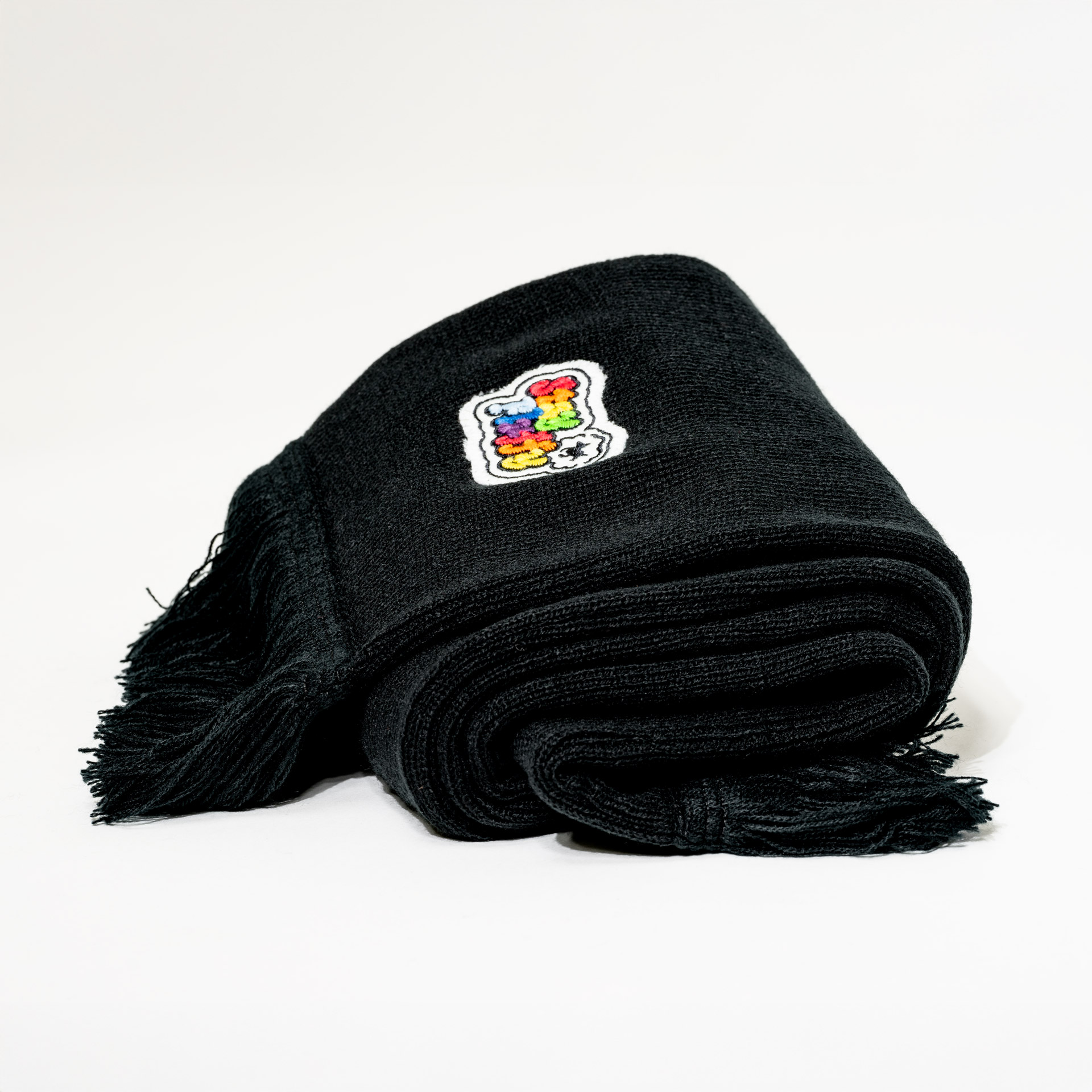 Side view of the rolled limited edition scarf "stay fluffy" on a white background