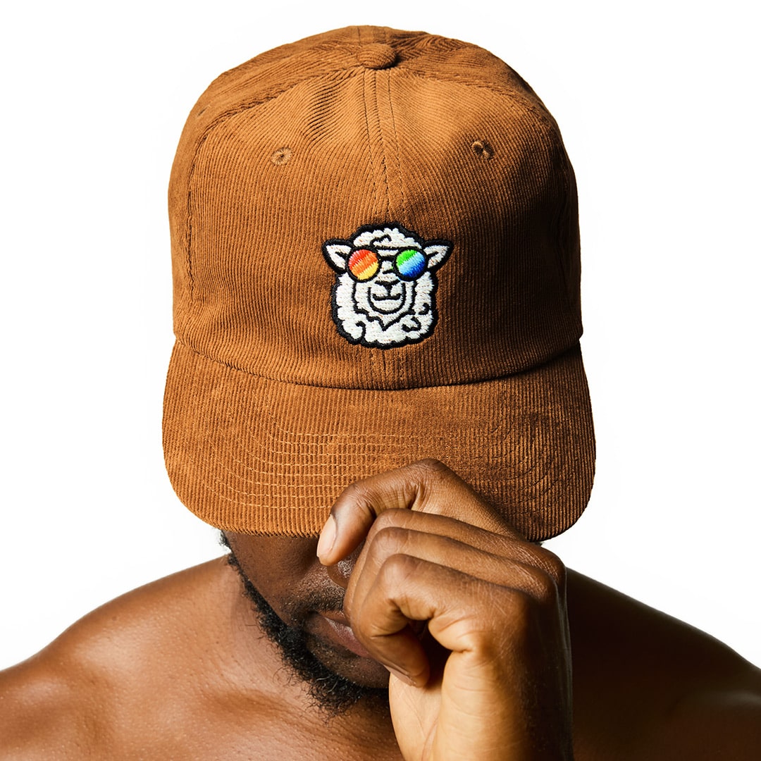 "Sunny" Corduroy Cap with a sheep motif made of gay sheep wool on a male model’s head.